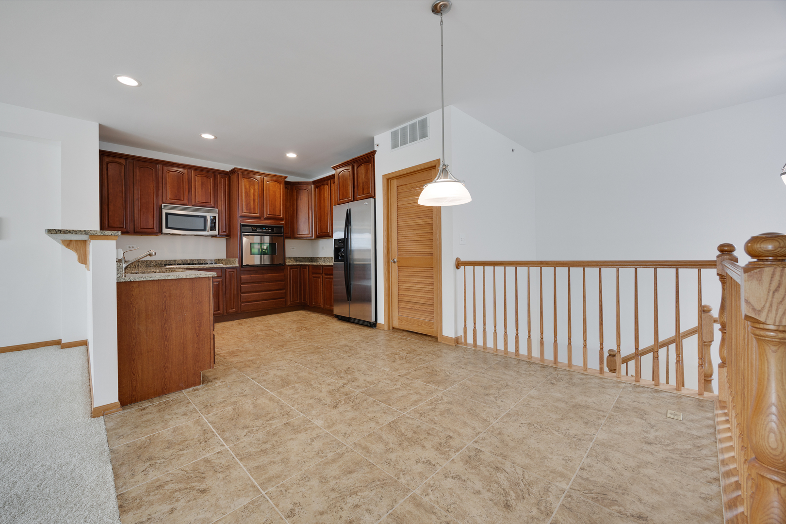 1385 Scarboro Road, Unit 204 Schaumburg, IL 60193 - Photo 4 of 18 a open kitchen with stainless steel appliances granite countertop a refrigerator a oven and a wooden cabinets