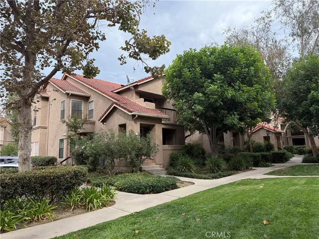 a front view of a house with a yard and trees