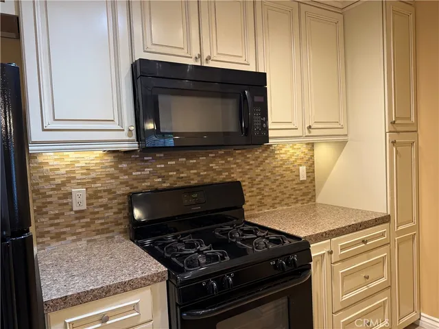 a kitchen with granite countertop a stove and a microwave