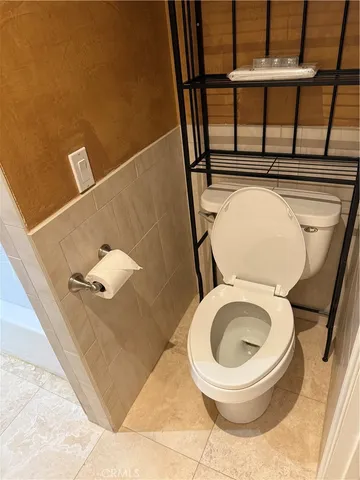 a bathroom with a toilet and a mirror