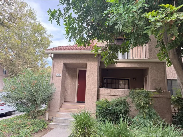 a front view of a house with a tree