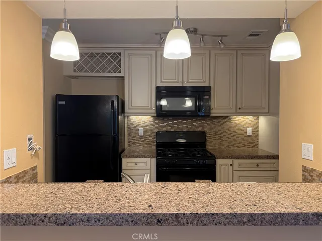 a kitchen with a refrigerator and a fireplace