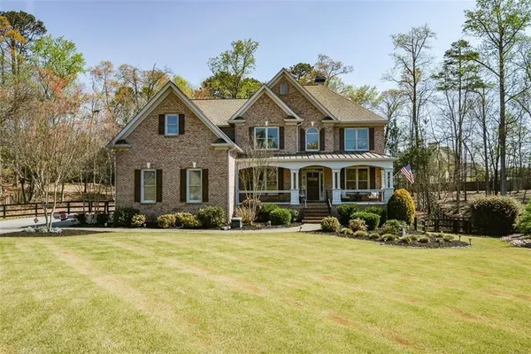 a view of a house with a big yard and large trees
