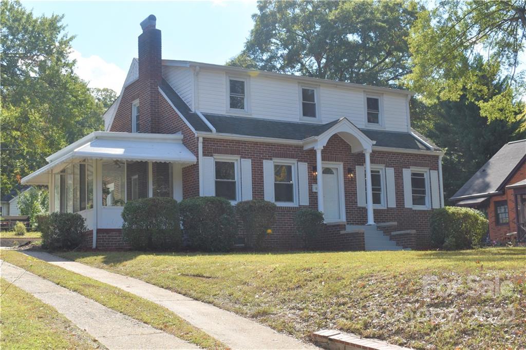 a front view of a house with a yard and trees