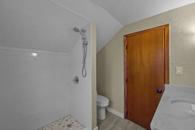 a bathroom with a granite countertop toilet a sink and shower