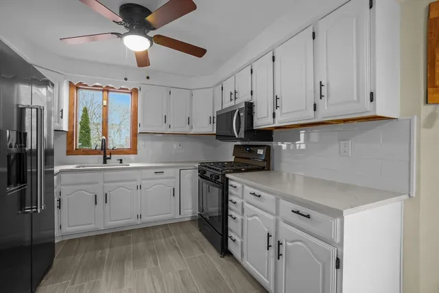 a kitchen with granite countertop white cabinets white stainless steel appliances with a sink and dishwasher