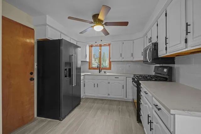 a kitchen with a refrigerator stove and white cabinets