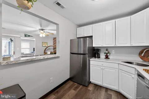 a kitchen with a sink stainless steel appliances and white cabinets