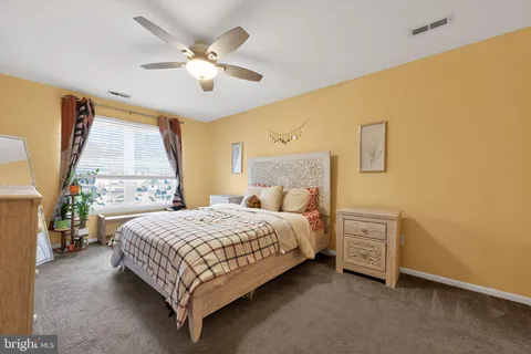 a bedroom with a bed lamp and a large window