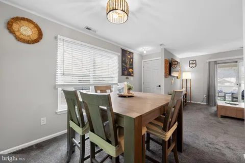 a view of a dining room with furniture and a chandelier
