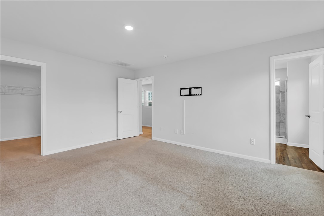 8 Leander Drive Greer, SC 29651 - Photo 10 of 31 A spacious bedroom with plush carpeting, offering easy access to an attached bath and a generous walk-in closet.