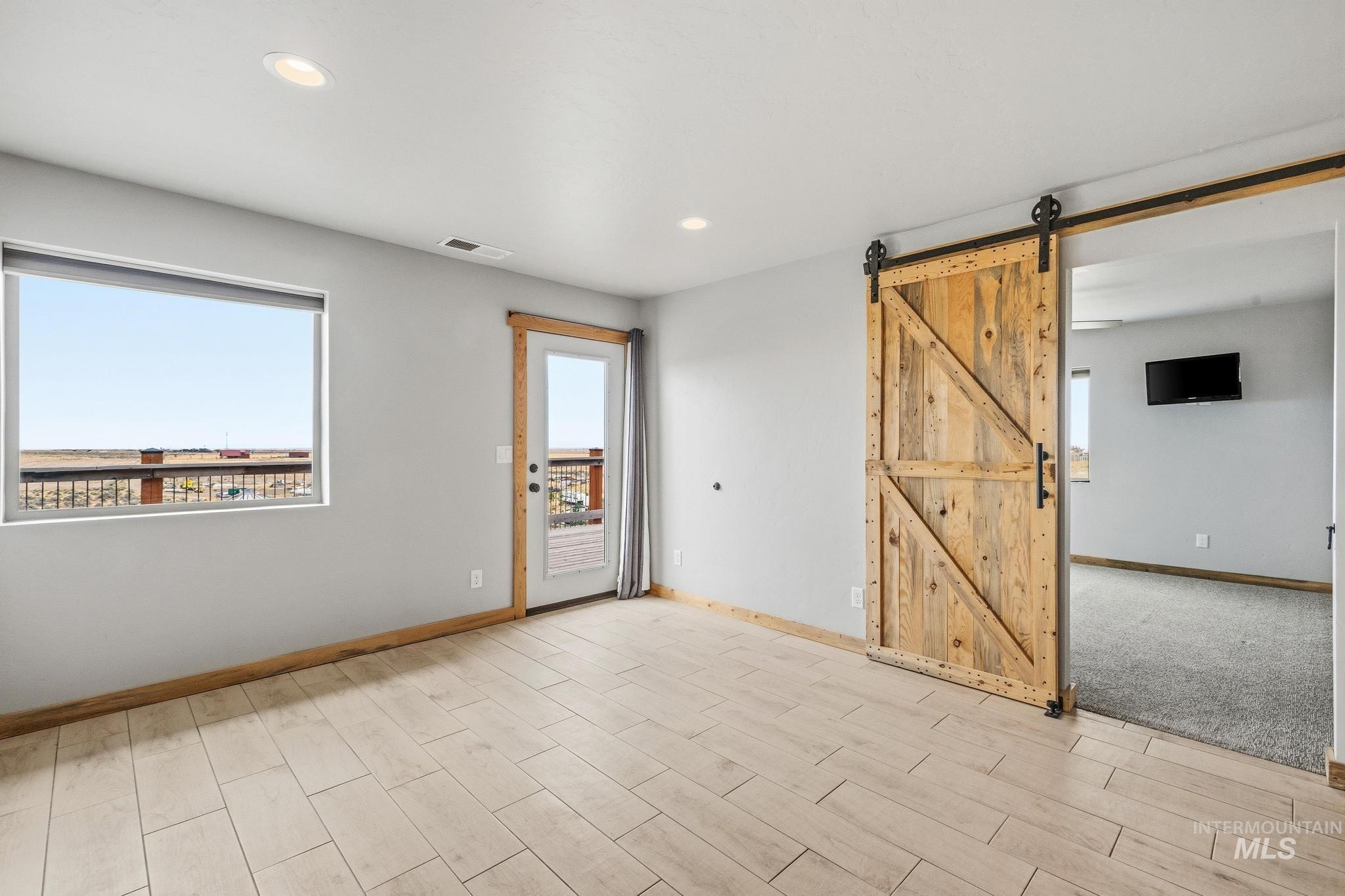 870 Desert Wind Road Boise, ID 83716 - Photo 33 of 50 Spacious room featuring light gray walls, textured gray carpeting, and a wood-finish baseboard trim