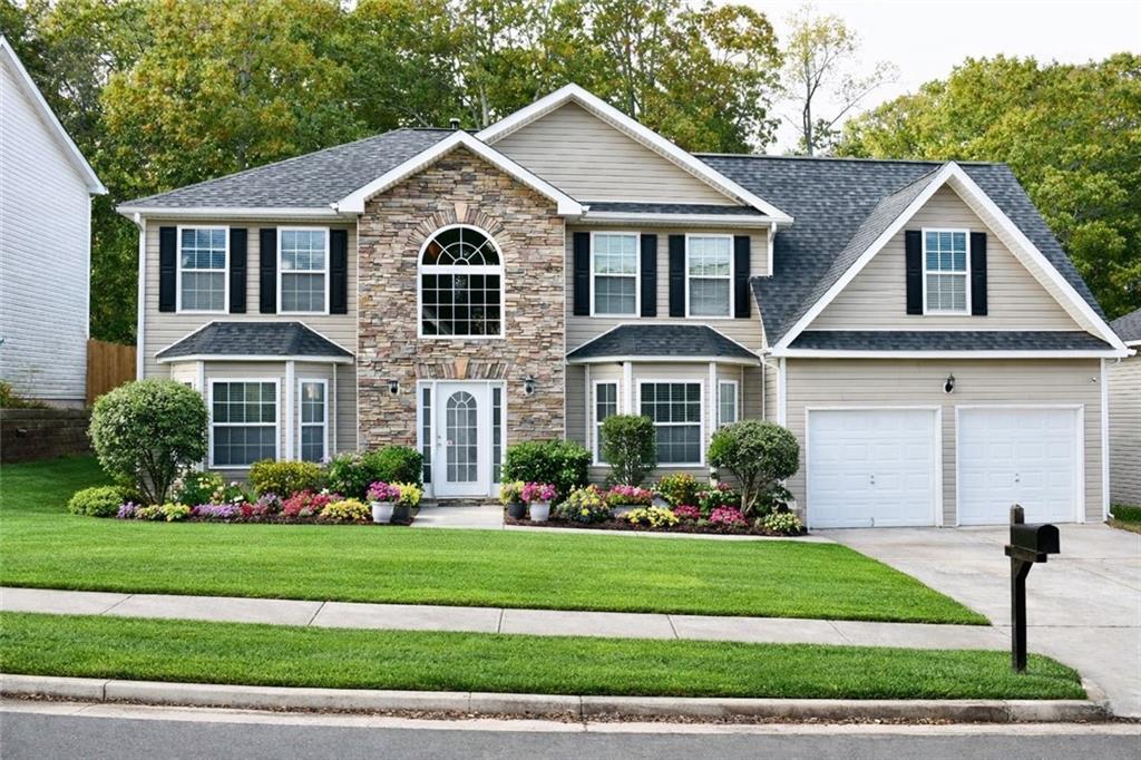 4381 Ash Tree Street Southwest Snellville, GA 30039 - Photo 1 of 1 a front view of a house with a yard and potted plants