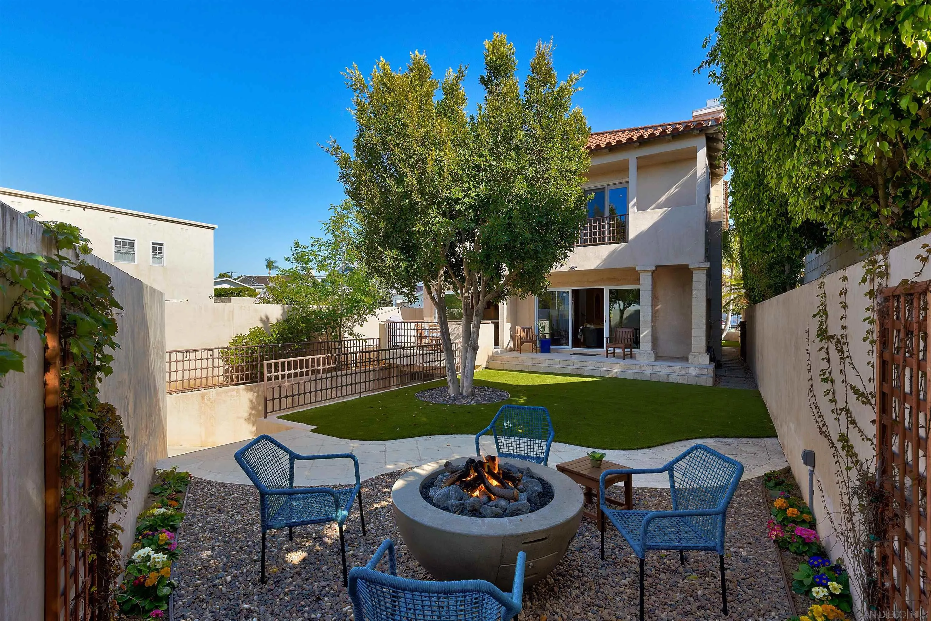 1022 G Coronado, CA 92118 - Photo 26 of 29 a view of a backyard with table and chairs potted plants and a large tree