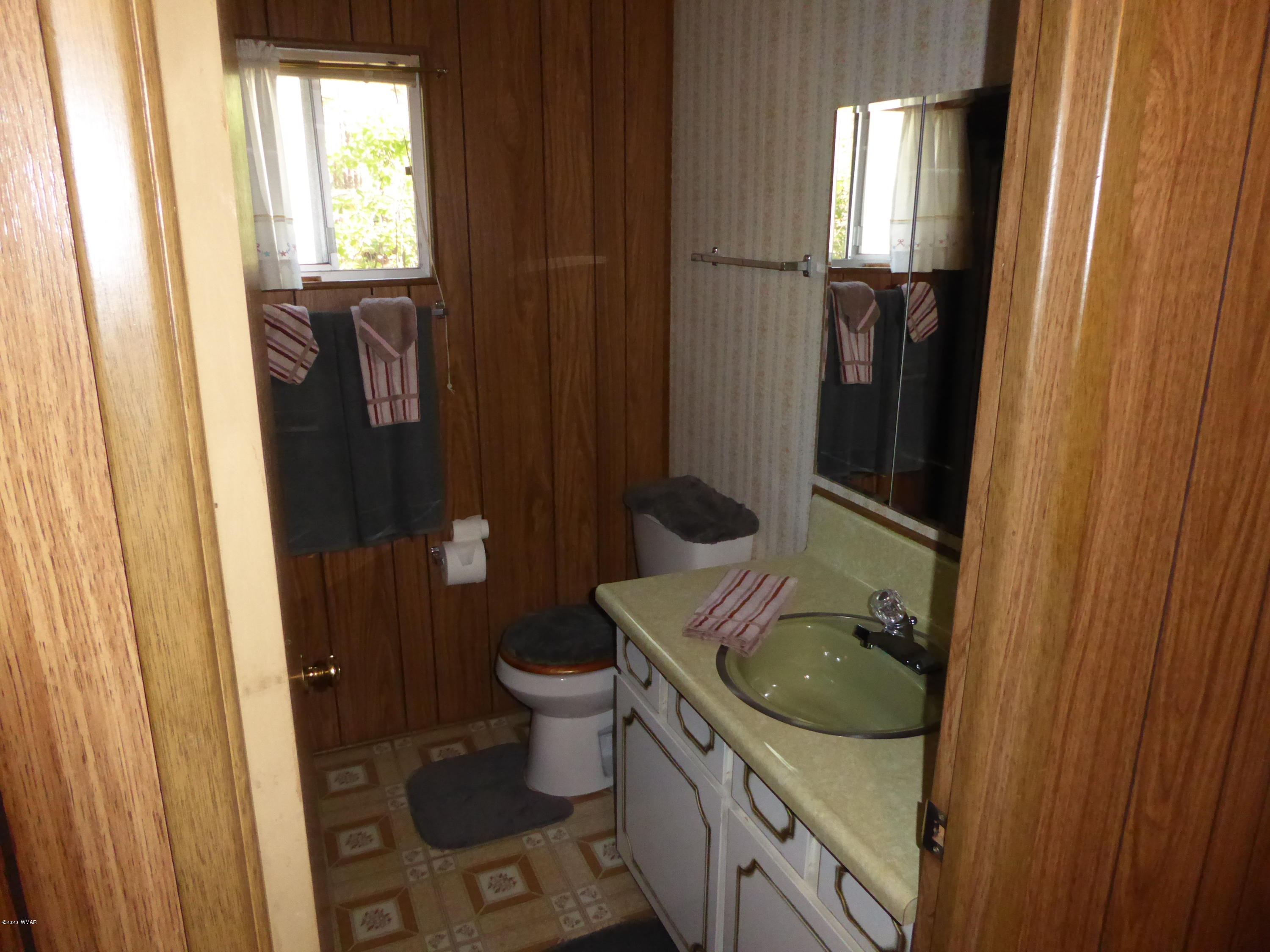 2898 Belle Road Overgaard, AZ 85933 - Photo 12 of 26 a bathroom with a granite countertop sink toilet and shower a mirror
