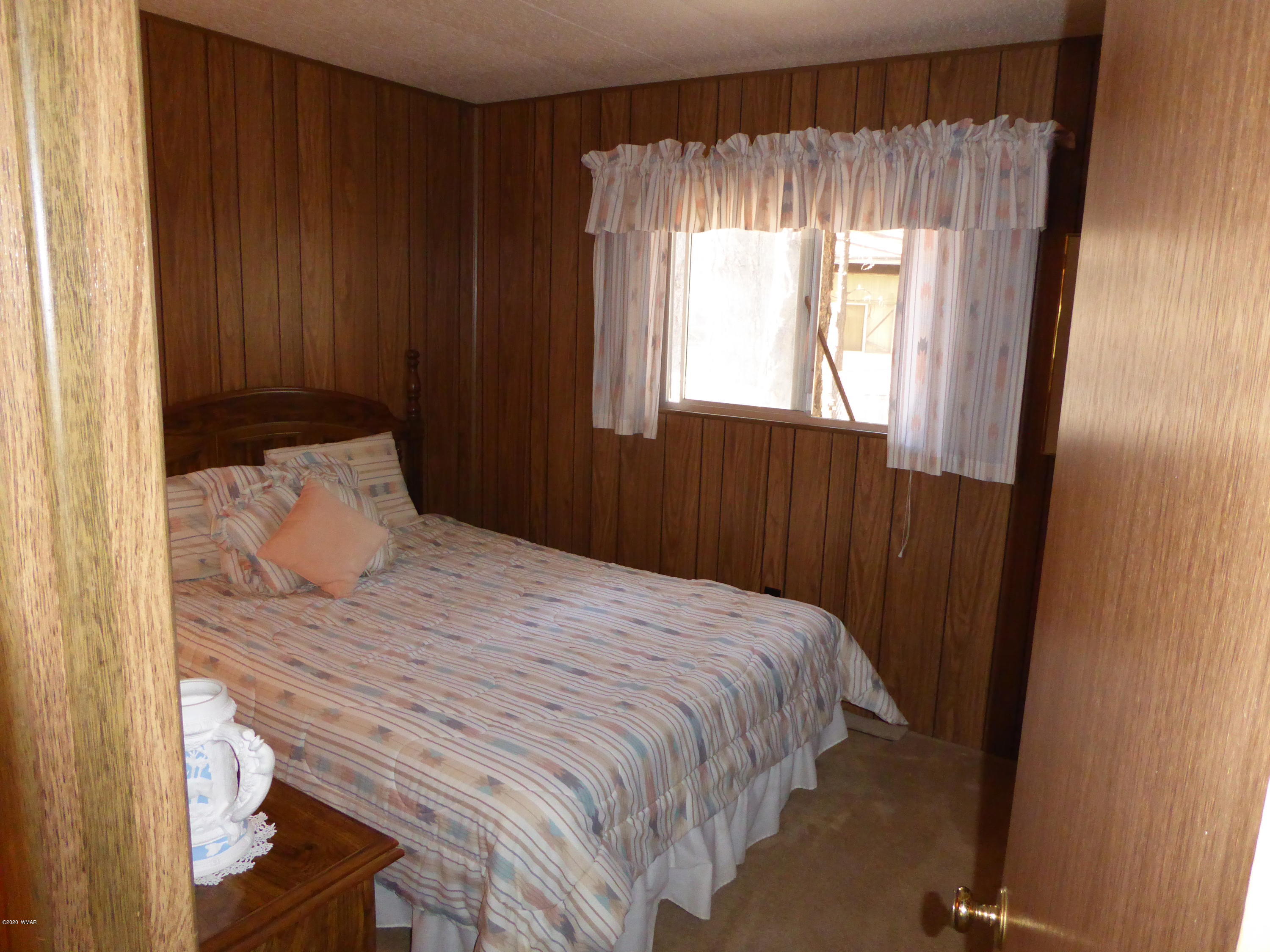 2898 Belle Road Overgaard, AZ 85933 - Photo 13 of 26 a bedroom with a bed and a window