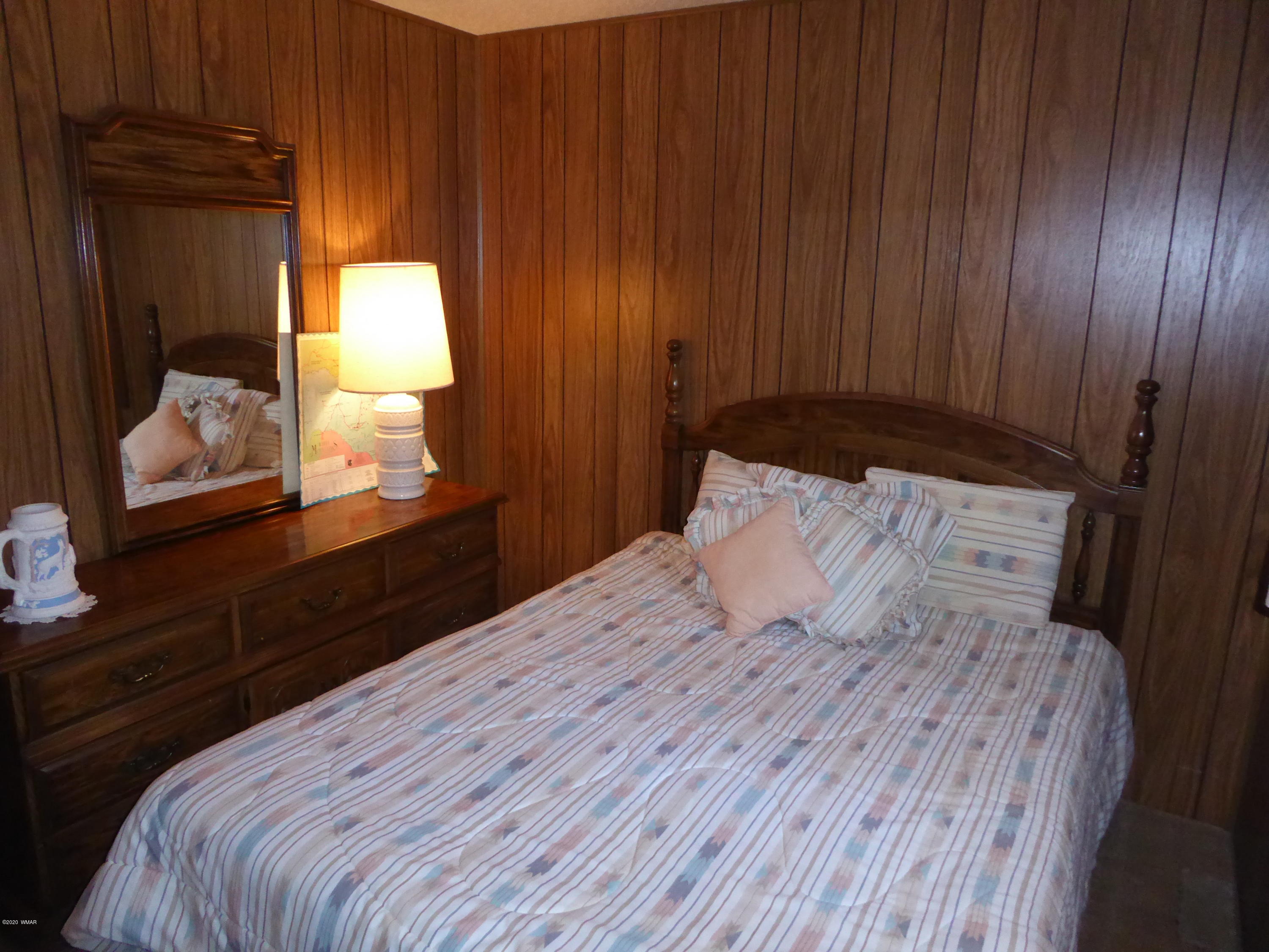 2898 Belle Road Overgaard, AZ 85933 - Photo 14 of 26 a bedroom with a bed and mirror