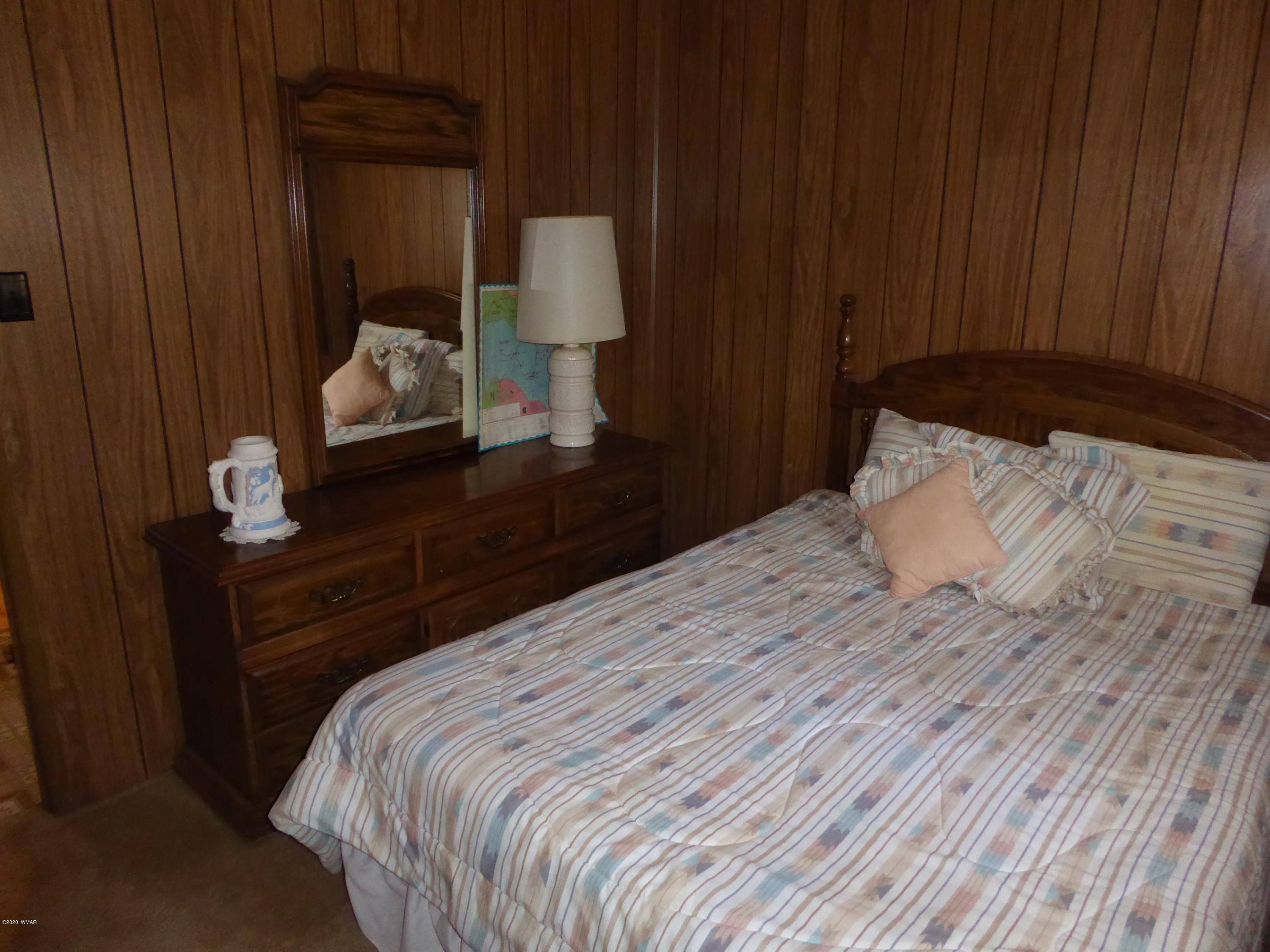 2898 Belle Road Overgaard, AZ 85933 - Photo 15 of 26 a bedroom with a bed and a night stand
