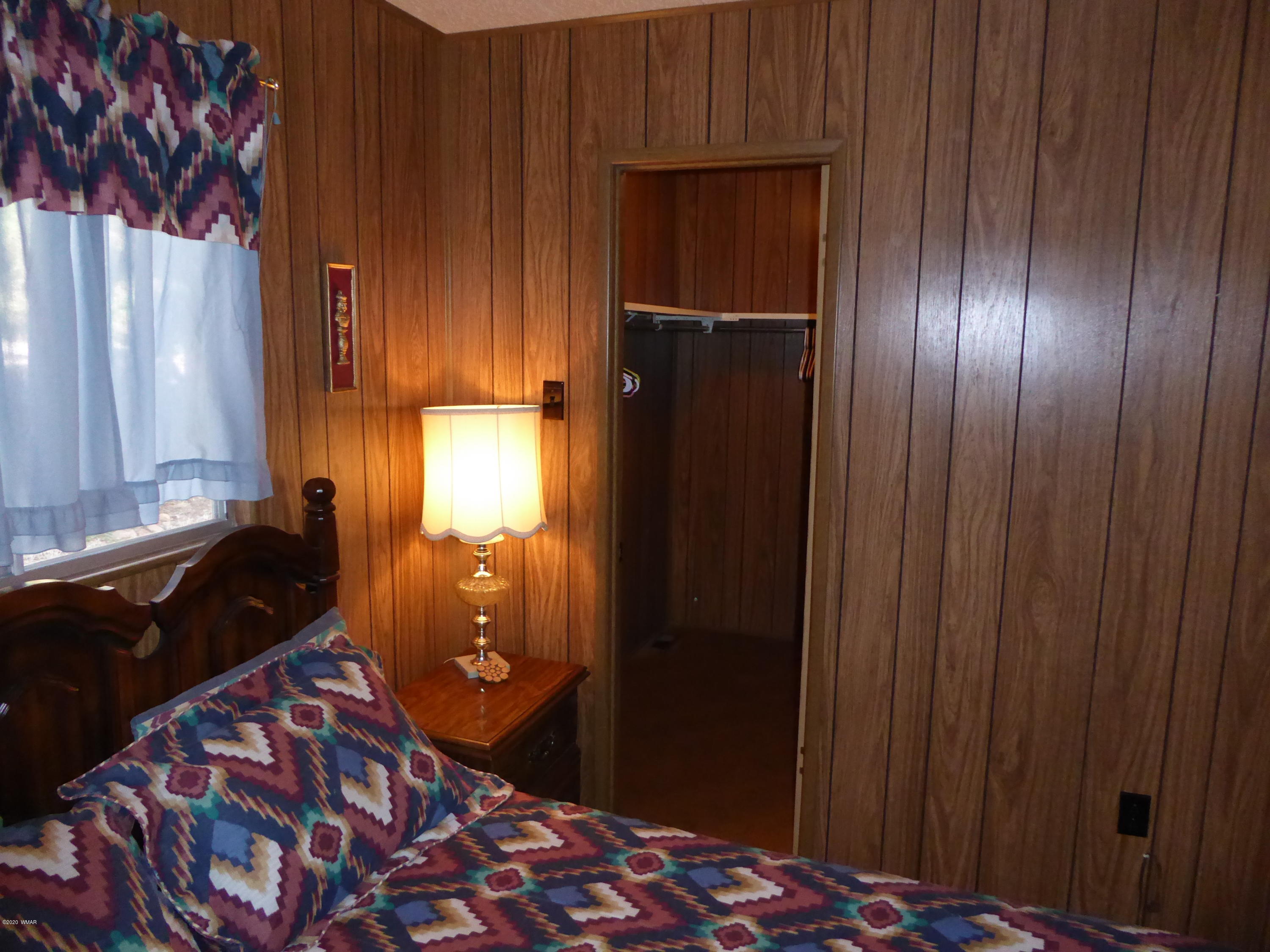 2898 Belle Road Overgaard, AZ 85933 - Photo 19 of 26 a bedroom with a bed and a dresser