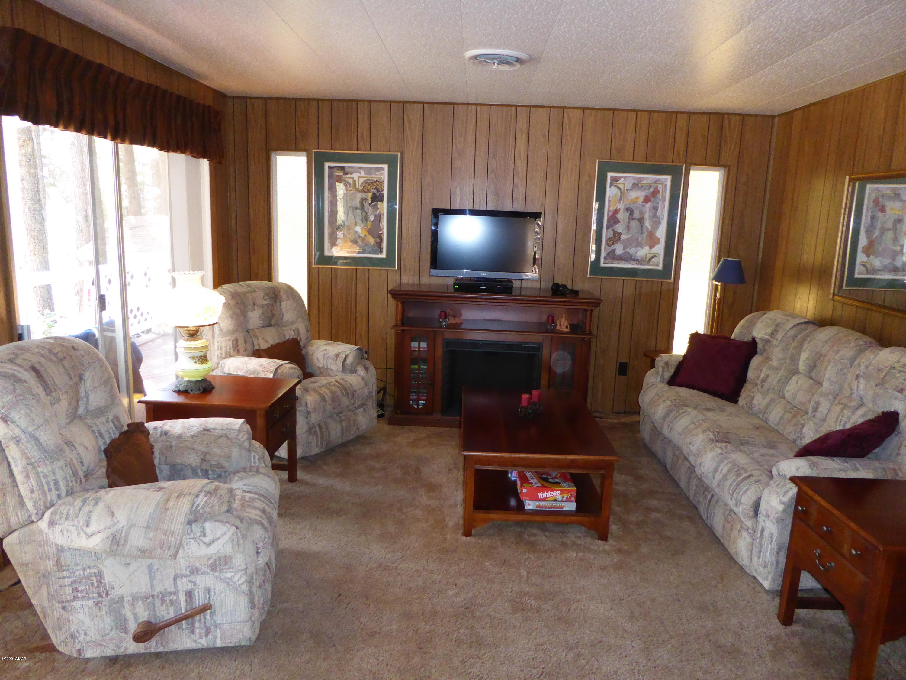 2898 Belle Road Overgaard, AZ 85933 - Photo 2 of 26 a living room with furniture and a flat screen tv