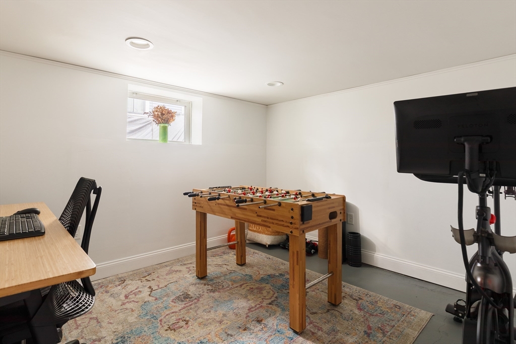 107 Grozier Road, Unit 1 Cambridge, MA 02138 - Photo 19 of 23 a work room with furniture and a flat screen tv
