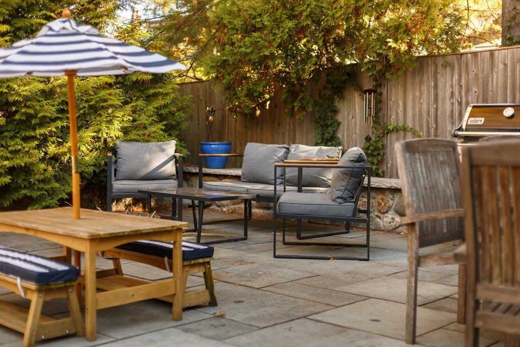 107 Grozier Road, Unit 1 Cambridge, MA 02138 - Photo 20 of 23 a backyard of a house with table and chairs