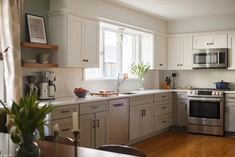 a kitchen with stainless steel appliances a stove a sink cabinets and a window