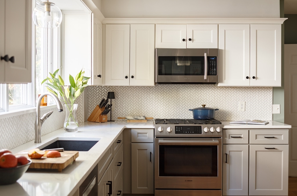 107 Grozier Road, Unit 1 Cambridge, MA 02138 - Photo 10 of 23 a kitchen with stainless steel appliances white cabinets and a stove
