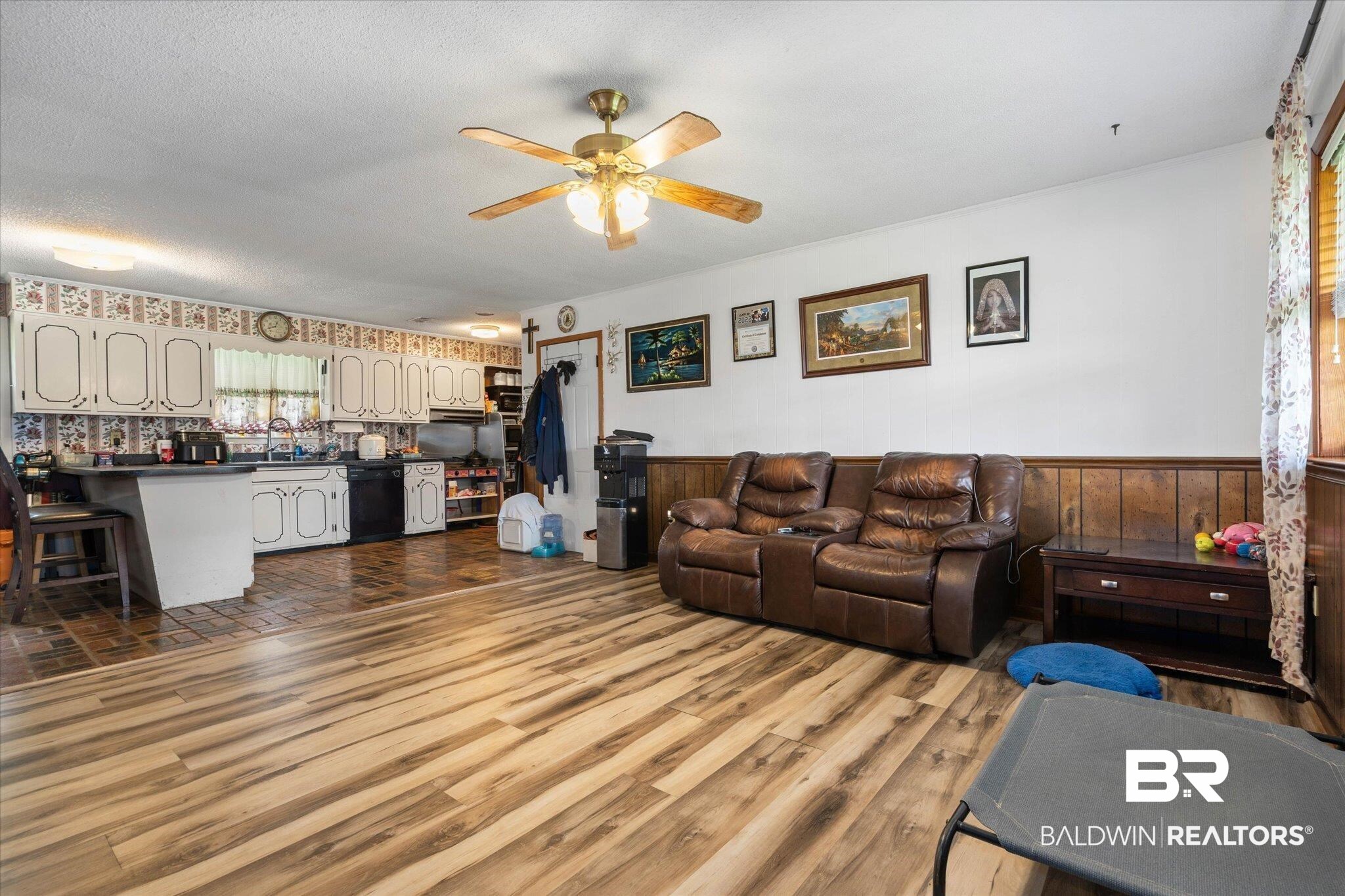 11601 Lott Road Chunchula, AL 36521 - Photo 3 of 34 Living room featuring ceiling fan, wainscoting, dark wood finished floors, and wood walls