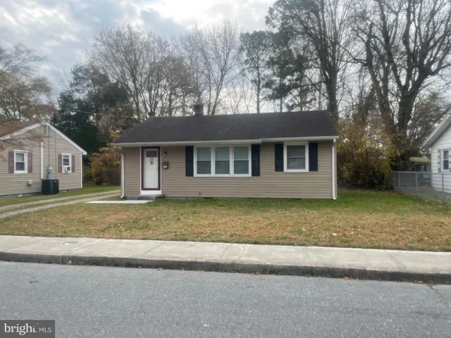 a view of a house with a yard and large tree
