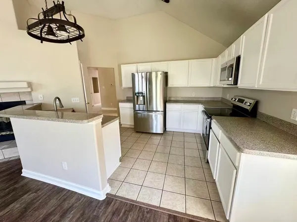 a view of a kitchen with wooden floor and electronic appliances