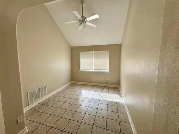 an empty room with windows and fan