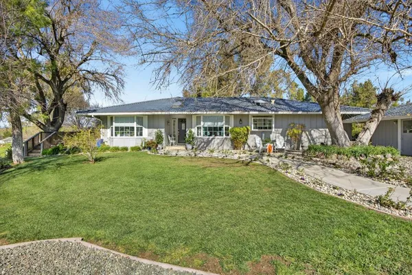 a view of a house with a yard and sitting area