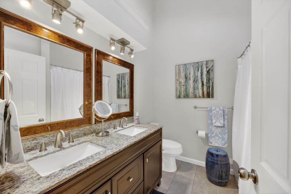 20690 County Road 79B Capay, CA 95607 - Photo 37 of 96 a bathroom with a granite countertop sink a toilet and a mirror