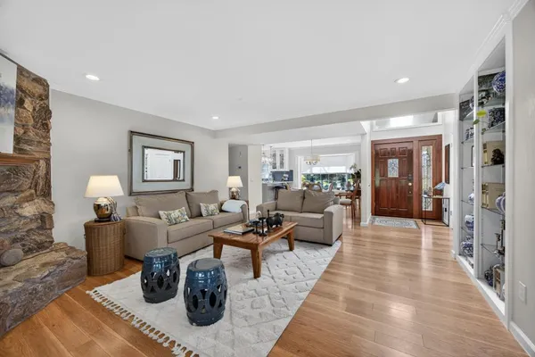 a view of a dining room and livingroom with furniture wooden floor a chandelier