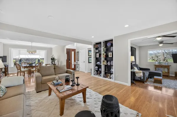a dining room with furniture a chandelier and wooden floor