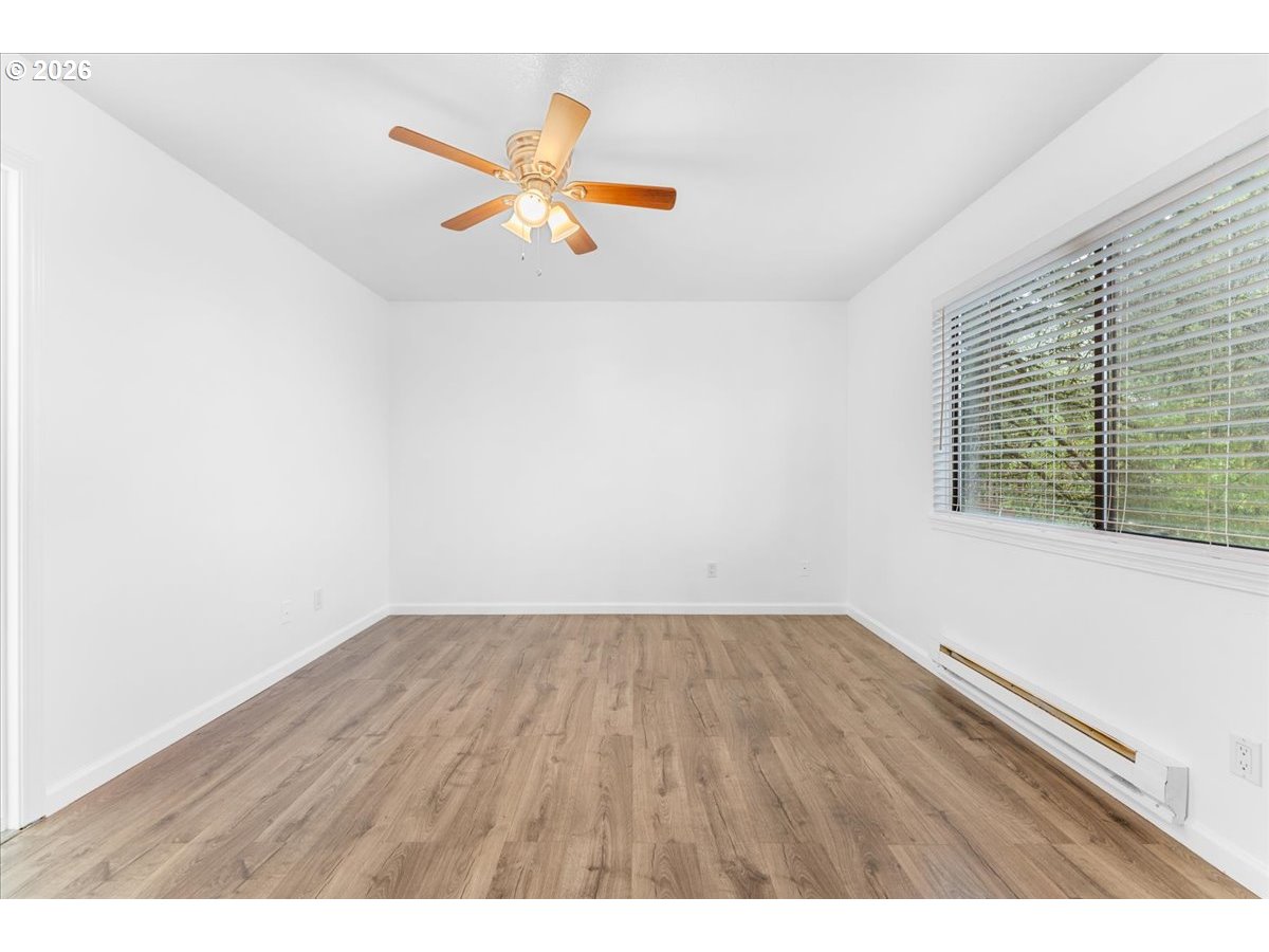 10160 Southeast Talbert Street Clackamas, OR 97015 - Photo 11 of 25 a view of an empty room with wooden floor and a window