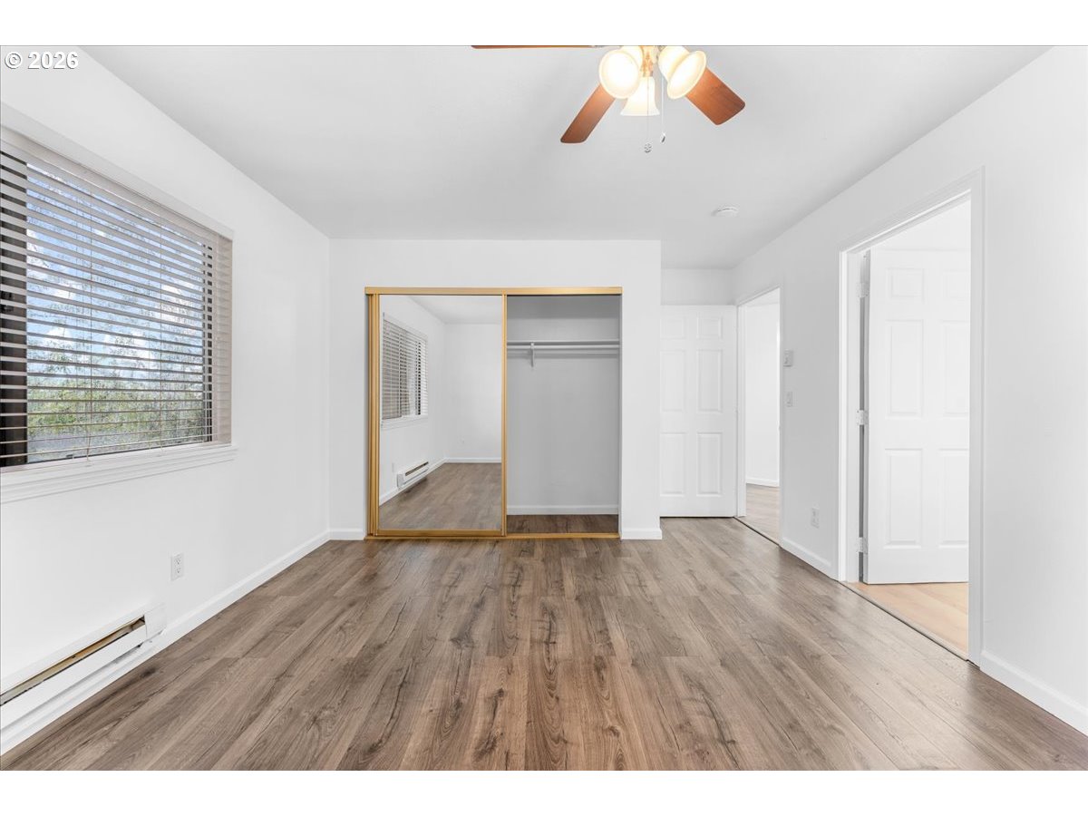 10160 Southeast Talbert Street Clackamas, OR 97015 - Photo 12 of 25 a view of an empty room with wooden floor and a window