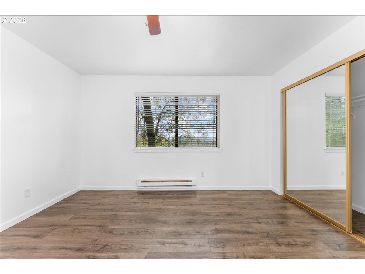 10160 Southeast Talbert Street Clackamas, OR 97015 - Photo 13 of 25 a view of an empty room with wooden floor and a window