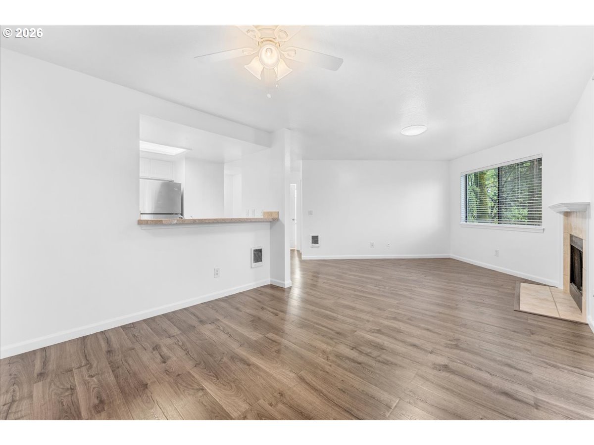 10160 Southeast Talbert Street Clackamas, OR 97015 - Photo 7 of 25 a view of an empty room with wooden floor and a window