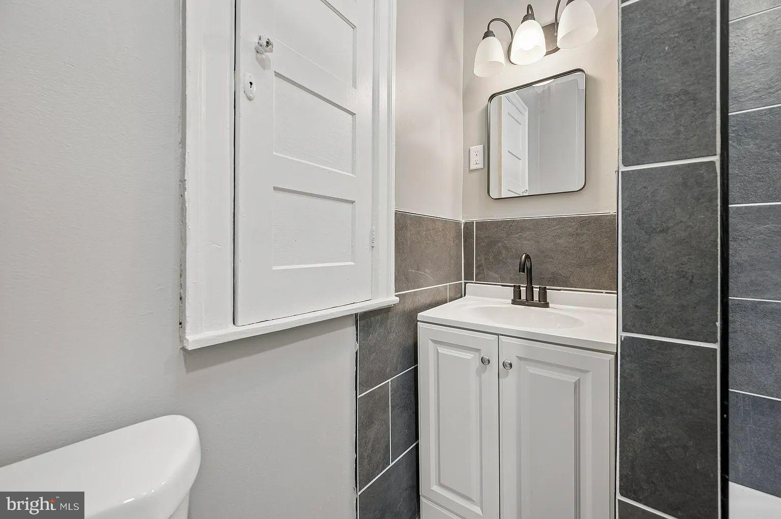 5625 Willows Avenue Philadelphia, PA 19143 - Photo 9 of 15 a bathroom with a sink a toilet and mirror