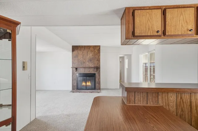 a kitchen with stainless steel appliances granite countertop a refrigerator a sink dishwasher and white cabinets with wooden floor