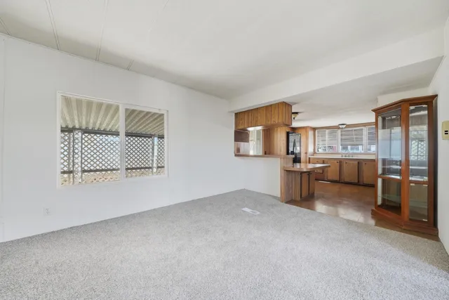 a view of a livingroom with an empty space and kitchen space