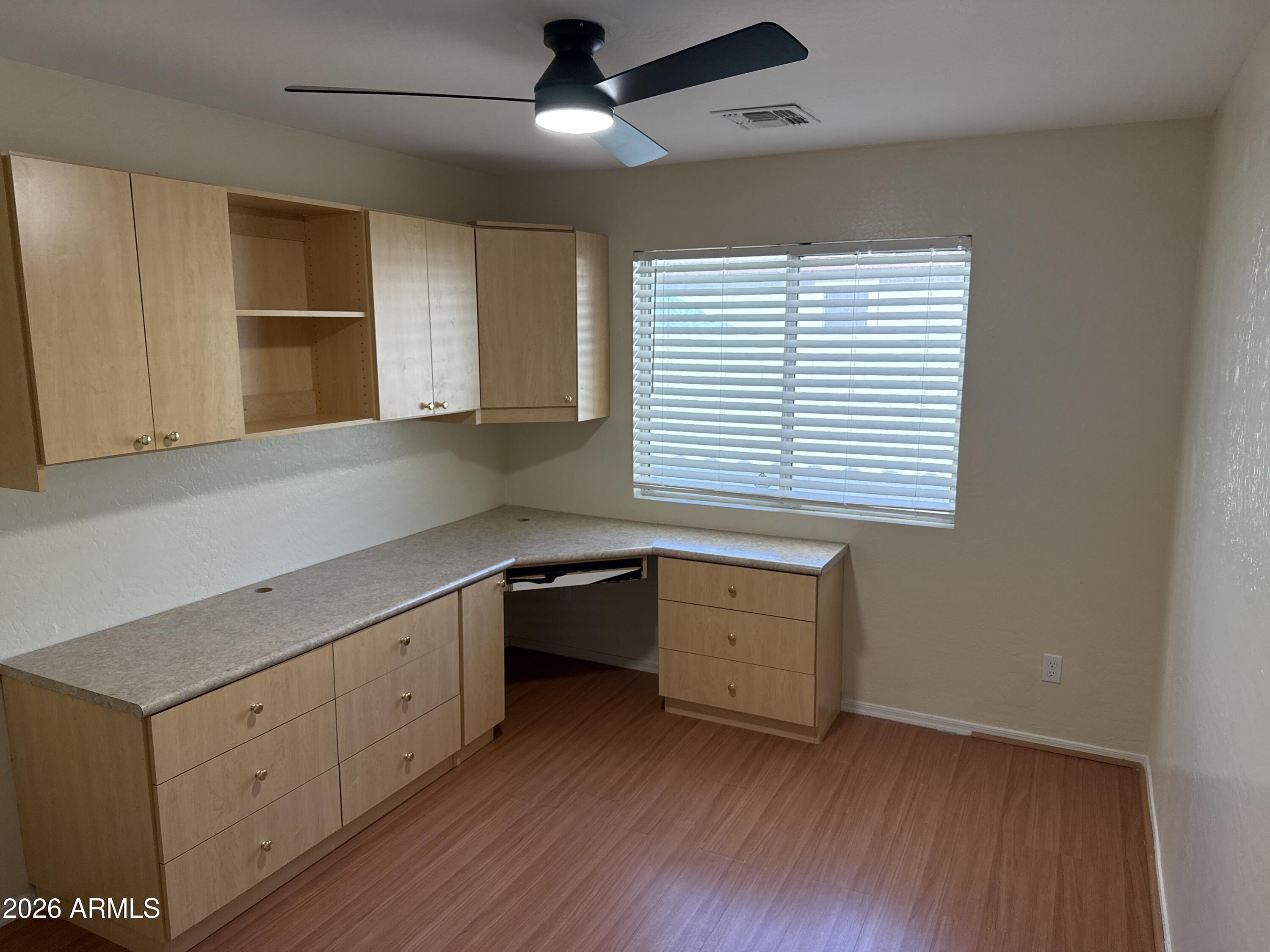 9630 West Reno View Drive Peoria, AZ 85345 - Photo 16 of 21 a kitchen with wooden floors and white cabinets