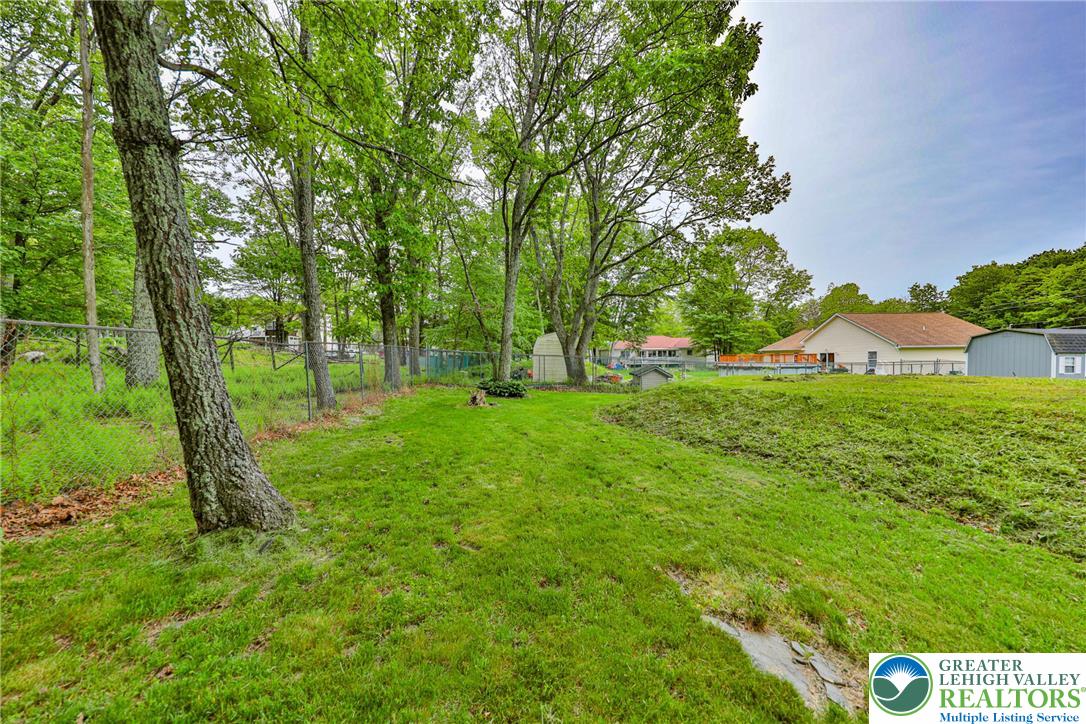 4608 Pine Ridge Drive West Bushkill, PA 18324 - Photo 59 of 62 A spacious backyard with mature trees and ample green space, perfect for outdoor recreation.