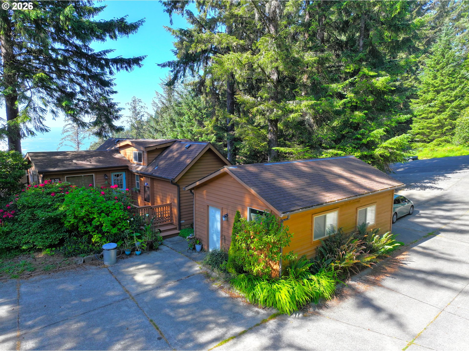 19921 Whaleshead Road, Unit U25 Brookings, OR 97415 - Photo 8 of 47 a view of a big house with large trees and plants