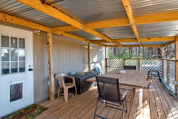 a view of a patio with table and chairs with wooden floor and fence