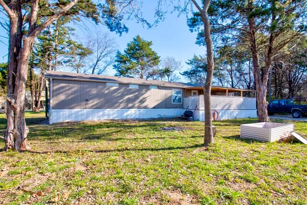 a view of backyard with wooden fence and large trees
