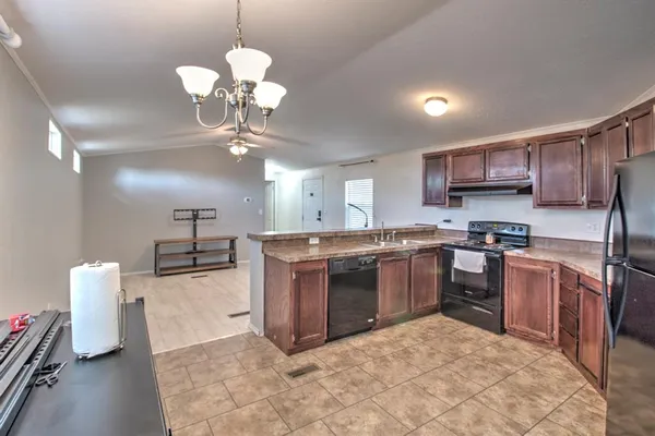 a kitchen with stainless steel appliances granite countertop a stove top oven a sink a counter top space and cabinets