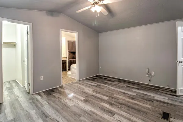 a view of an empty room with wooden floor and closet